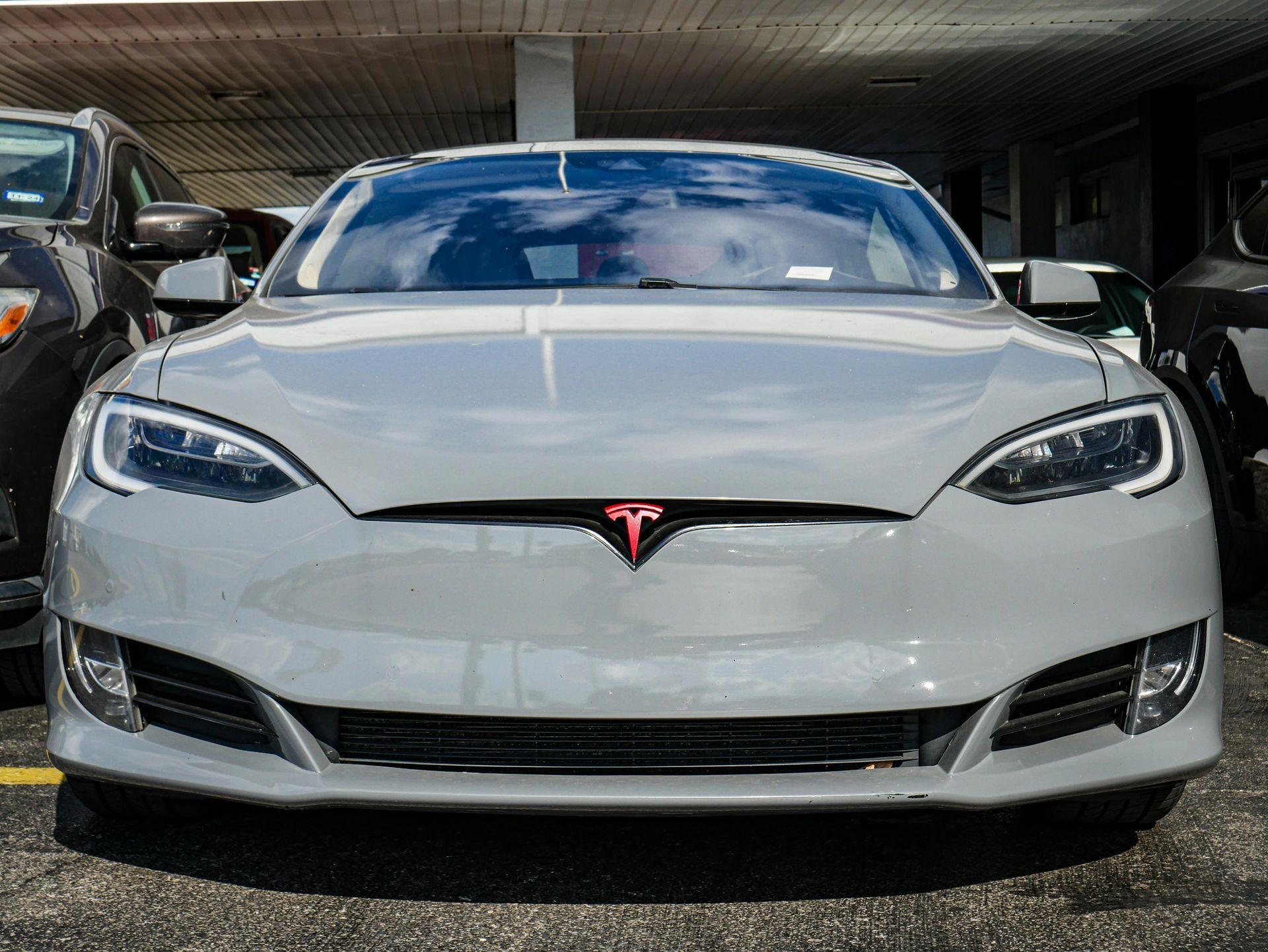 Front view of a white Tesla Model S parked in a garage
