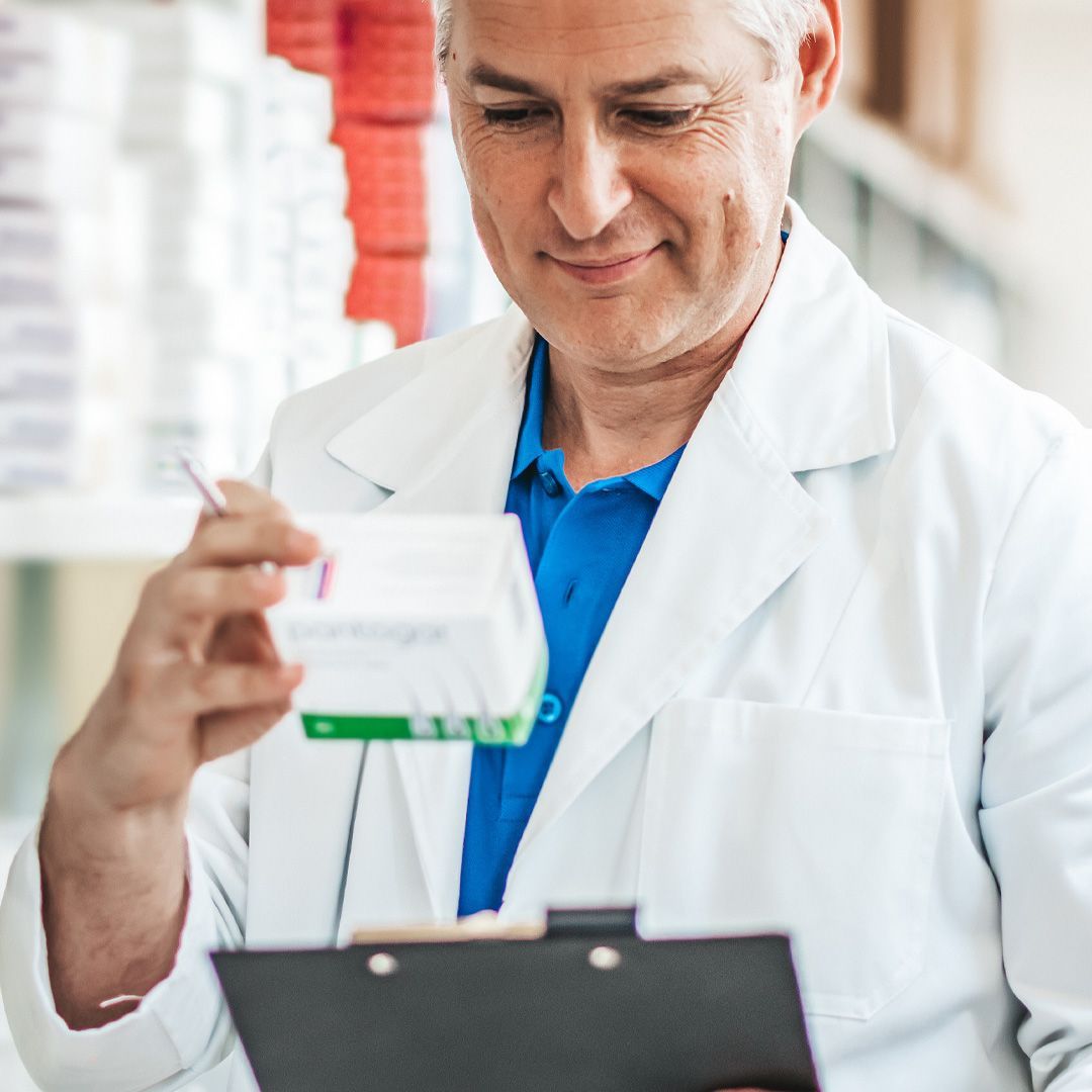 A pharmacist is looking at a prescription in a pharmacy.