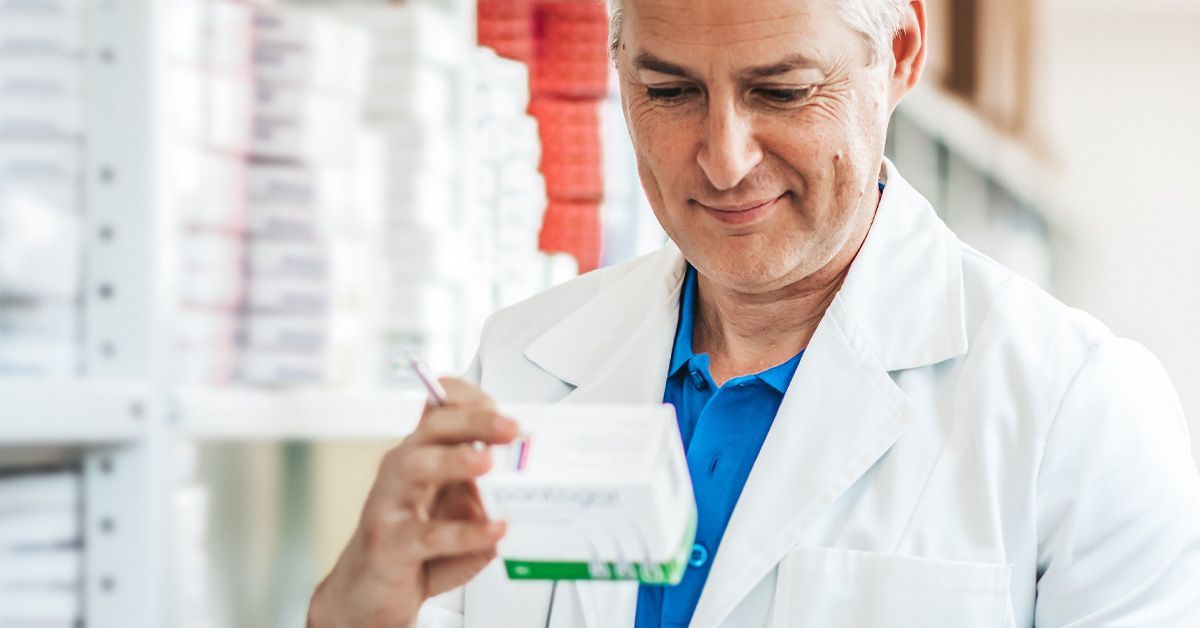 A pharmacist is looking at a prescription in a pharmacy.