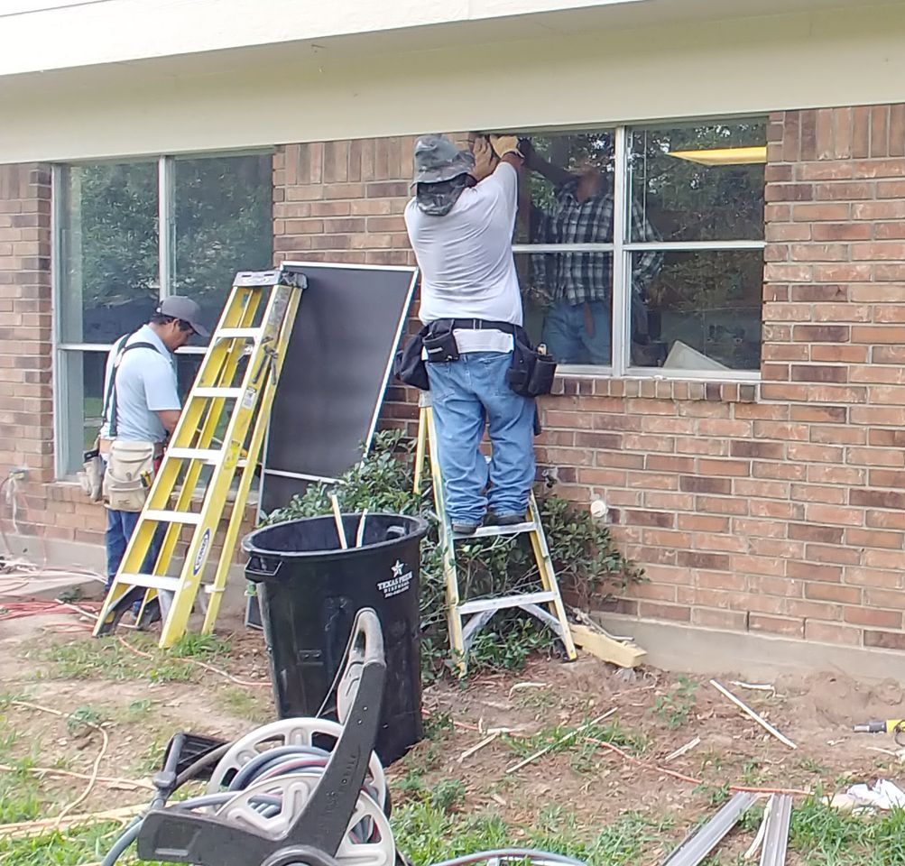 Person installing a wooden framed screen in a skylight.