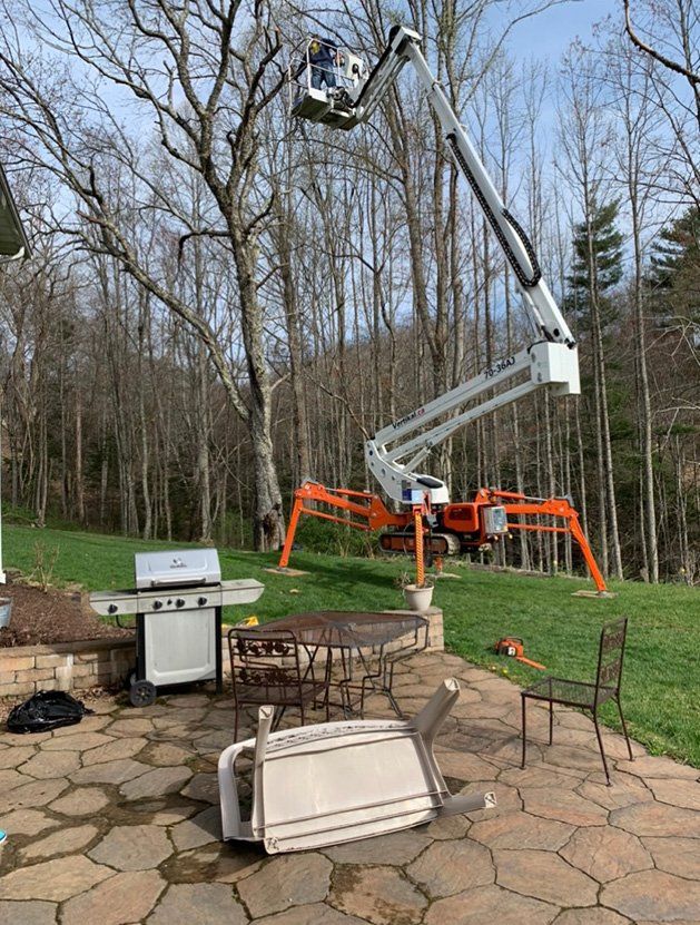 Seat and table in front of aerial lift — Daniels, WV — Mastiff Lawn & Tree Care