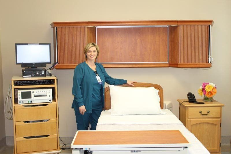 A nurse is standing next to a hospital bed