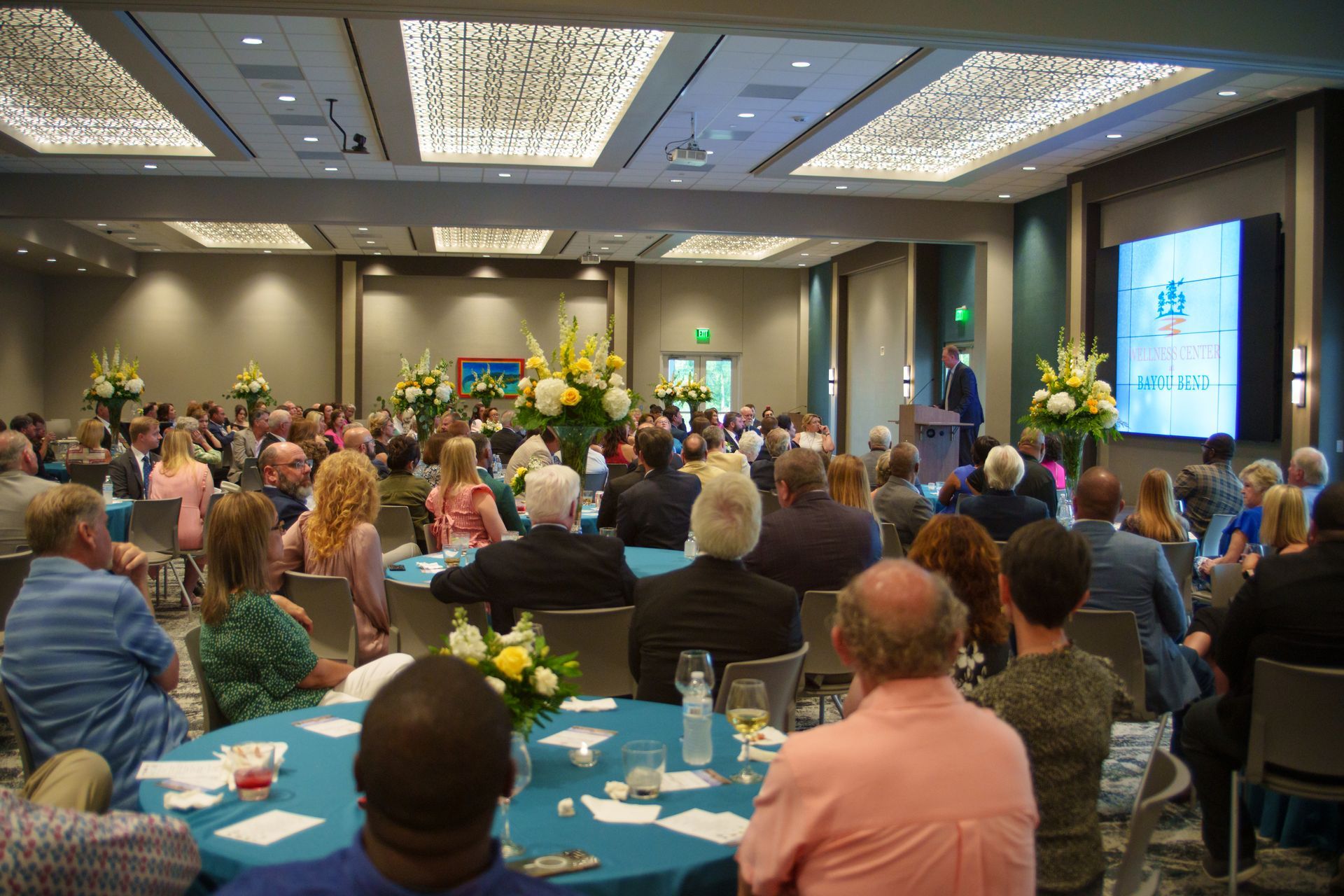 A large group of people are sitting at tables in a large room.
