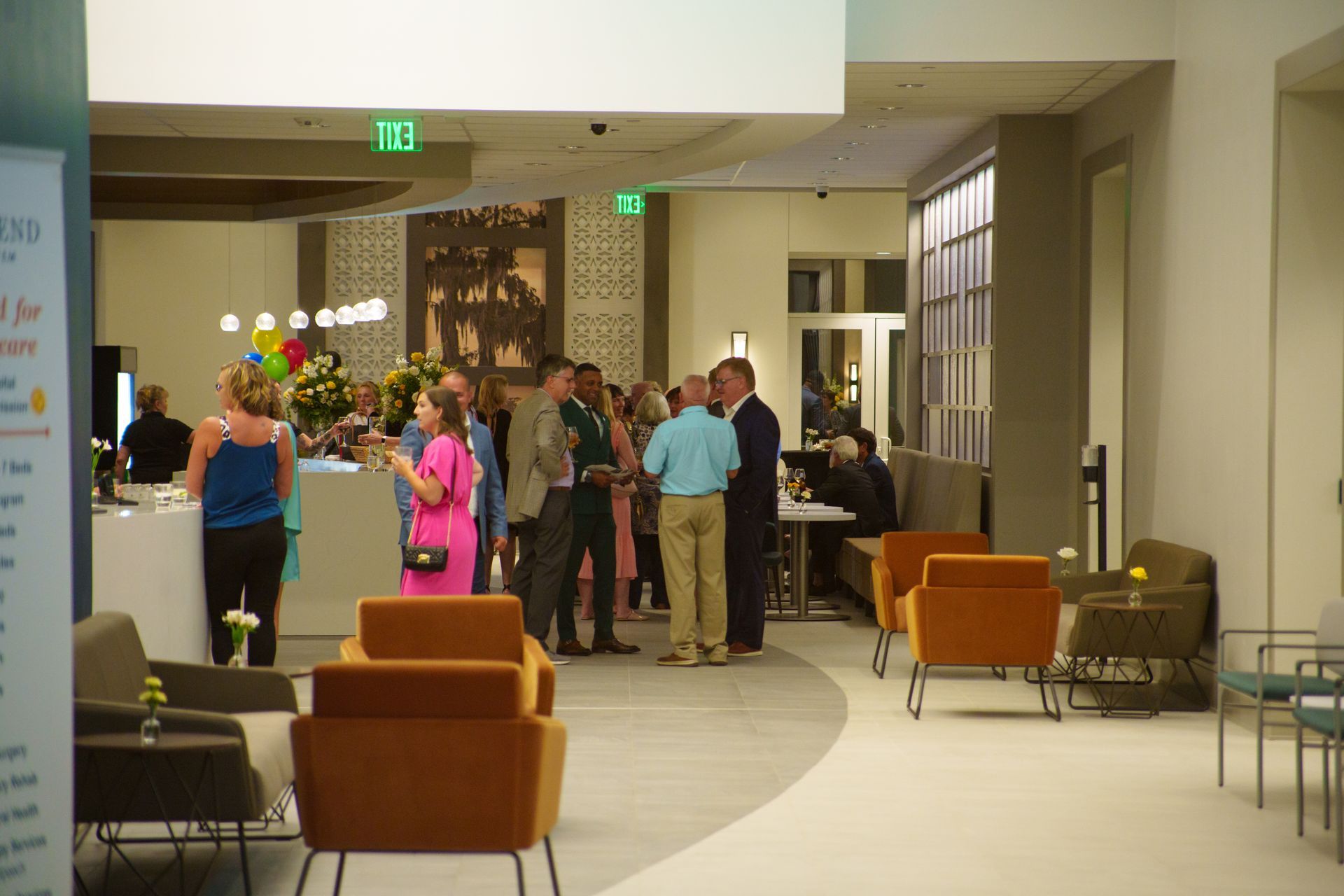 A group of people are standing in a lobby talking to each other.