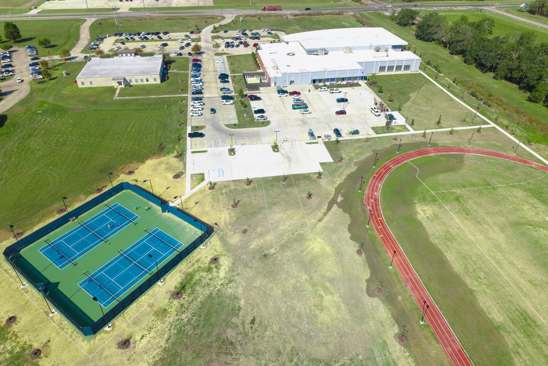 An arial view of the fitness center, parking lot, tennis court, and walking track