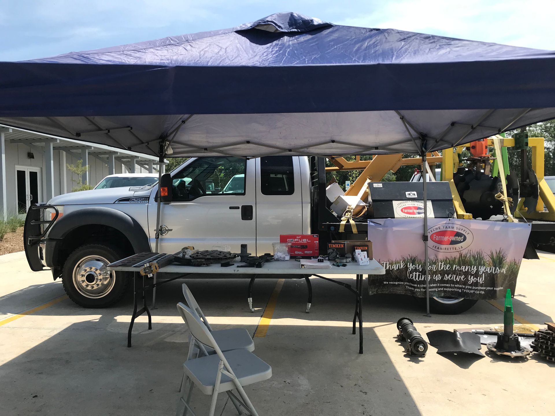A truck is parked under a tent in a parking lot.