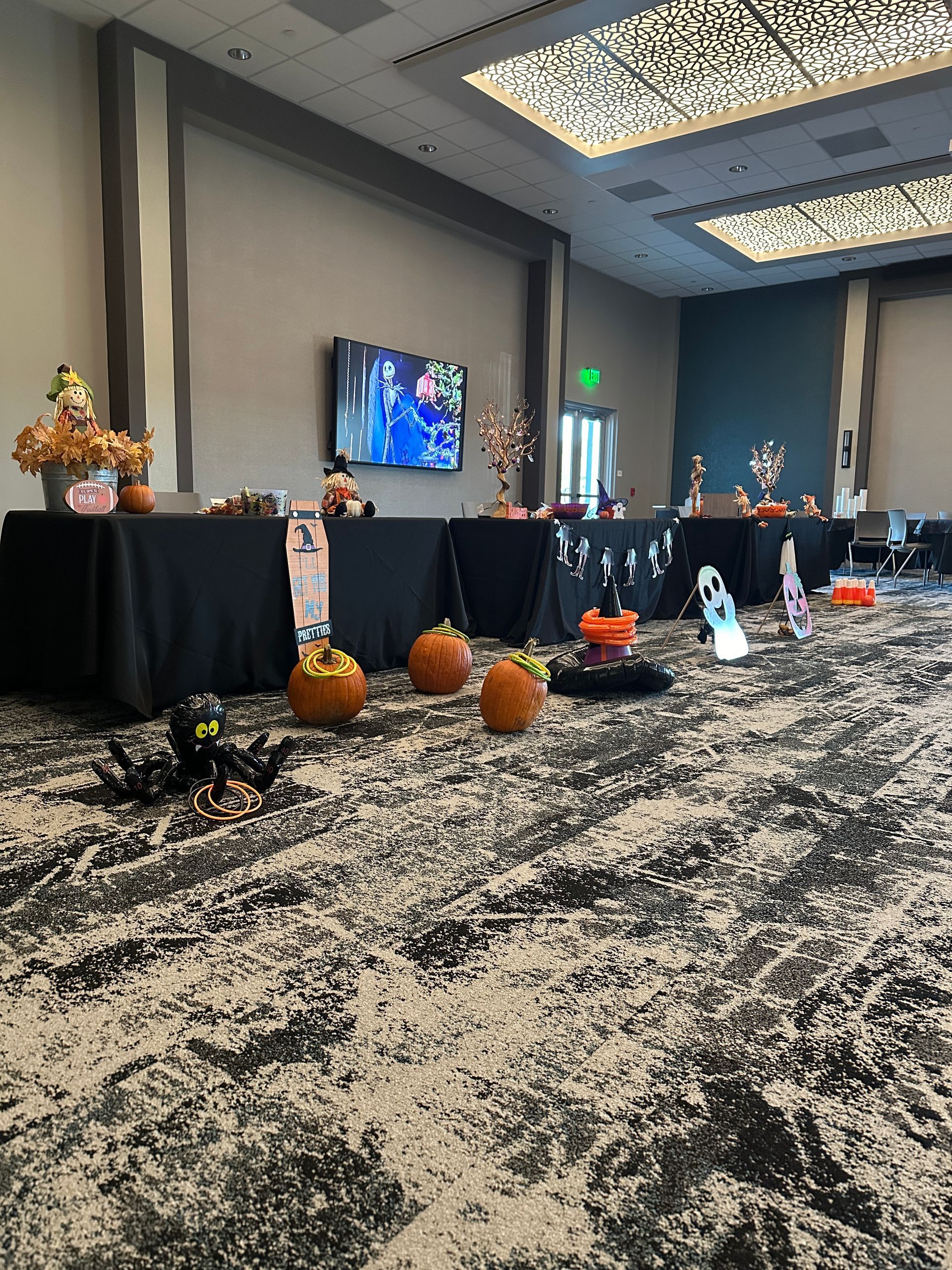 A large room with tables and pumpkins on the floor.