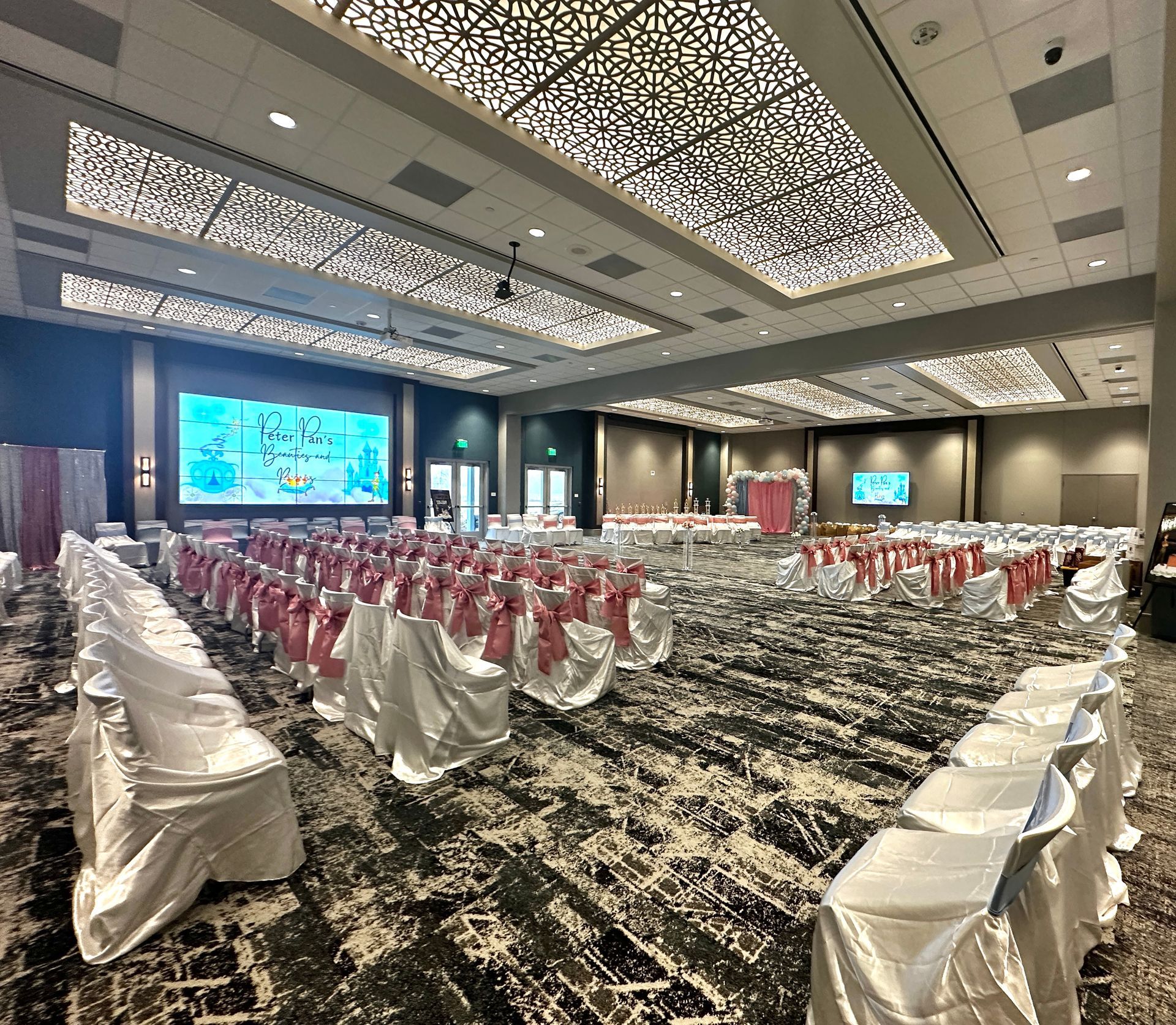 A large room with rows of chairs and a large screen.