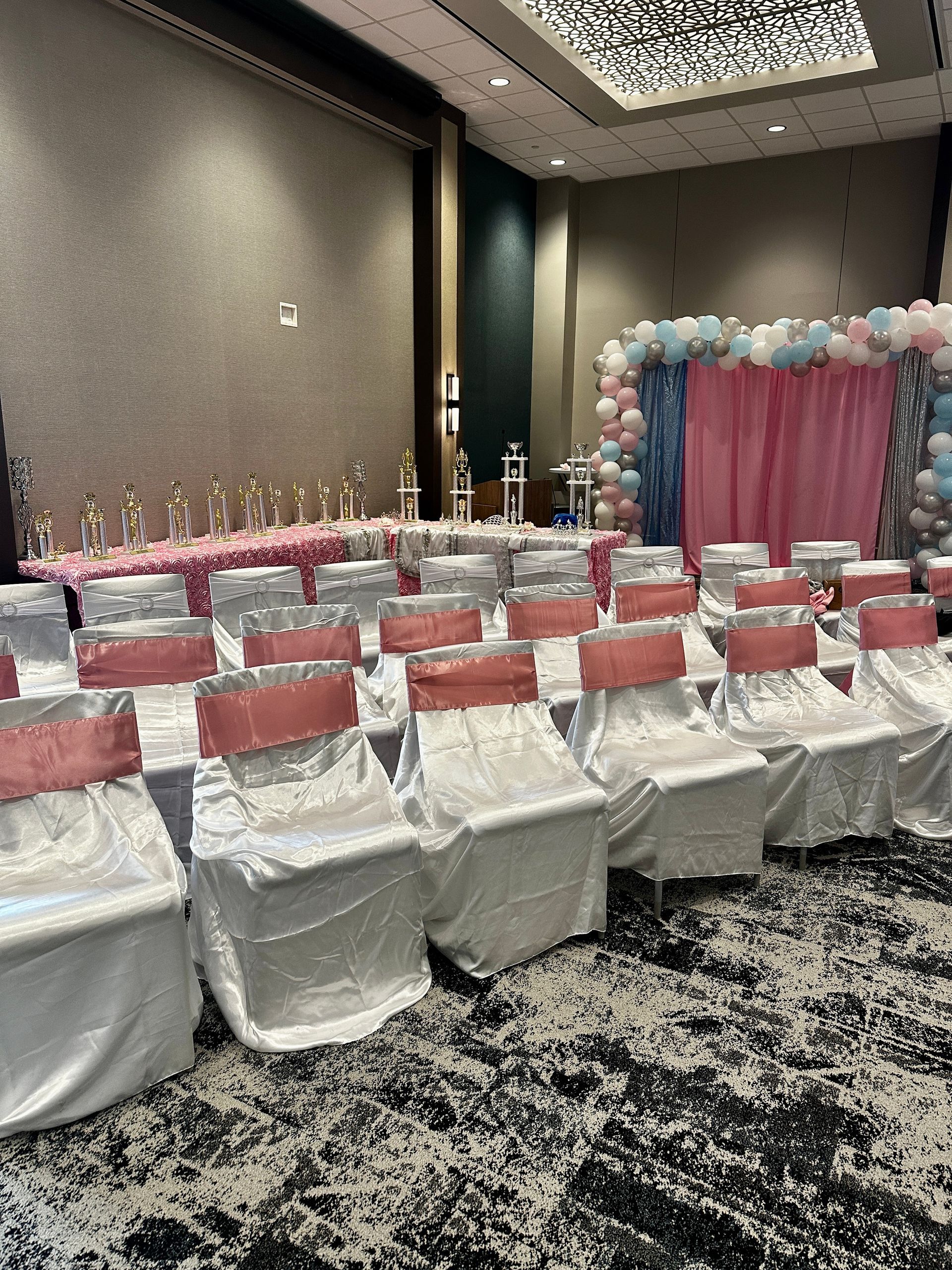 A room filled with chairs and tables and balloons.