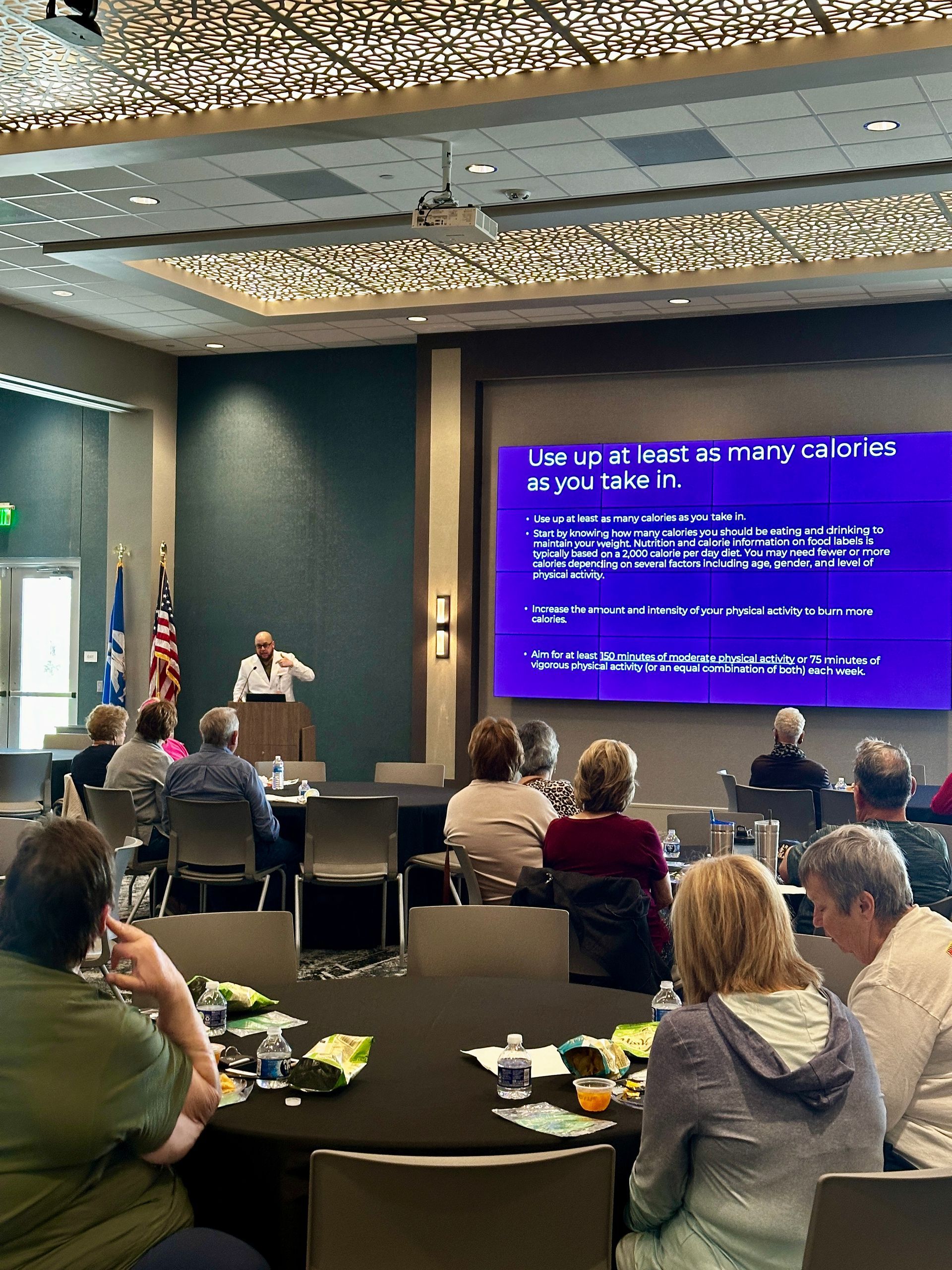 A man is giving a presentation to a group of people in a conference room.