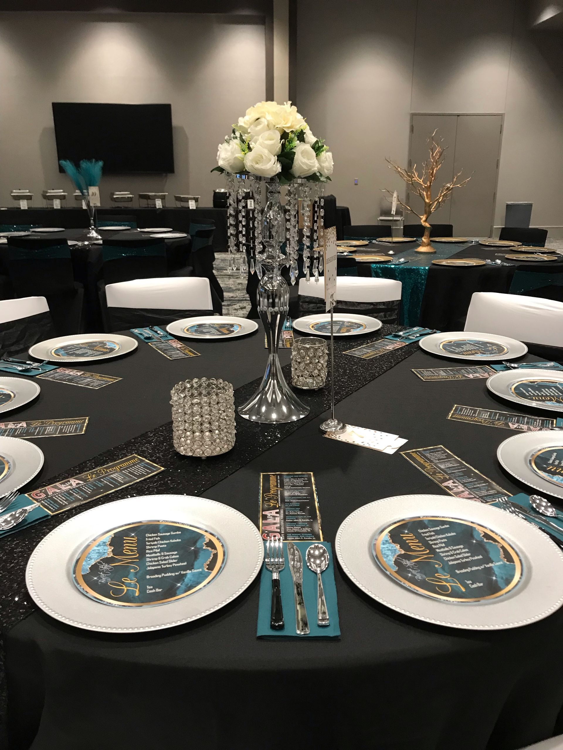 A table set for a party with plates , silverware , and a vase of flowers.