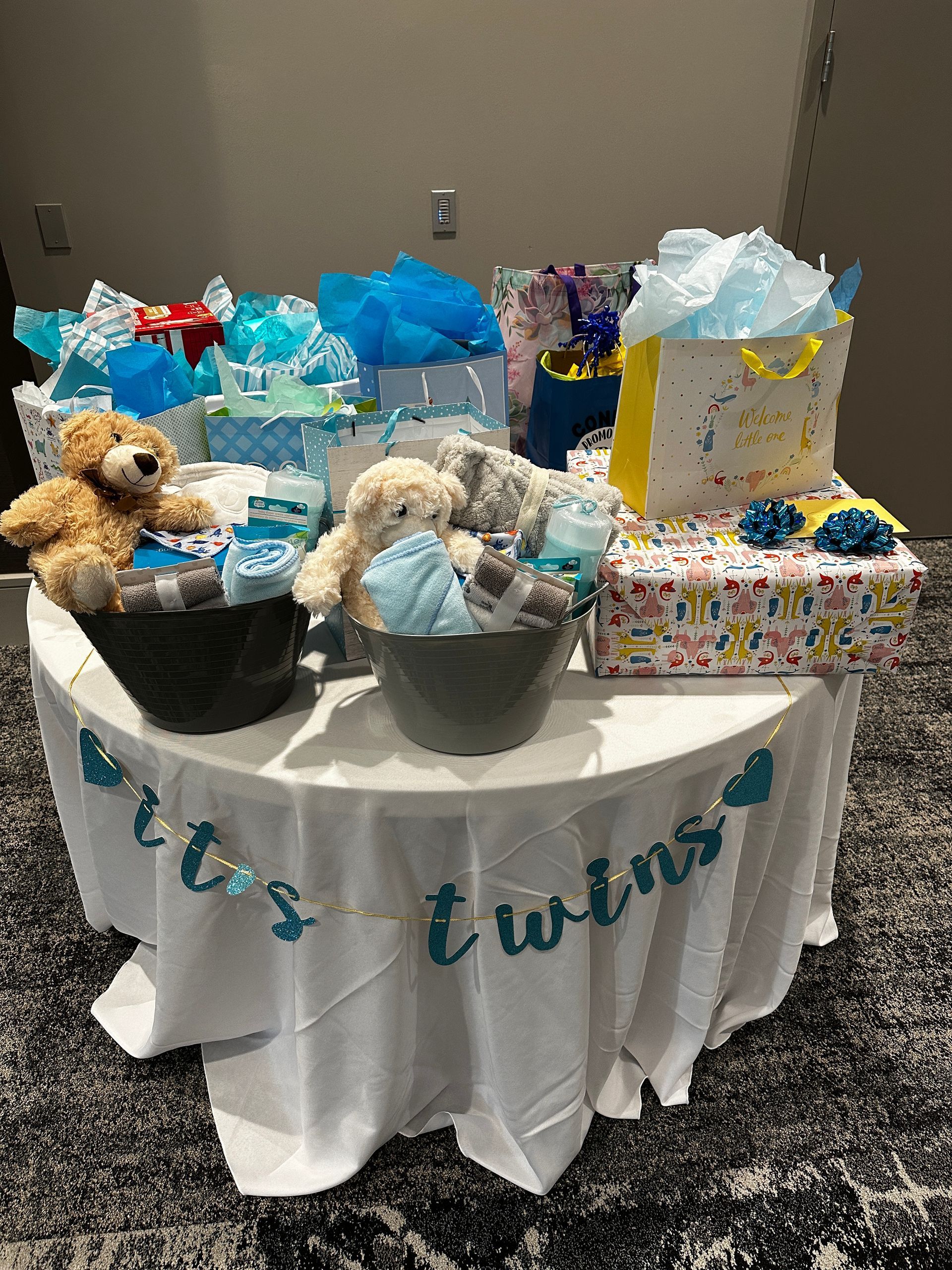A table filled with gifts and teddy bears for a baby shower.