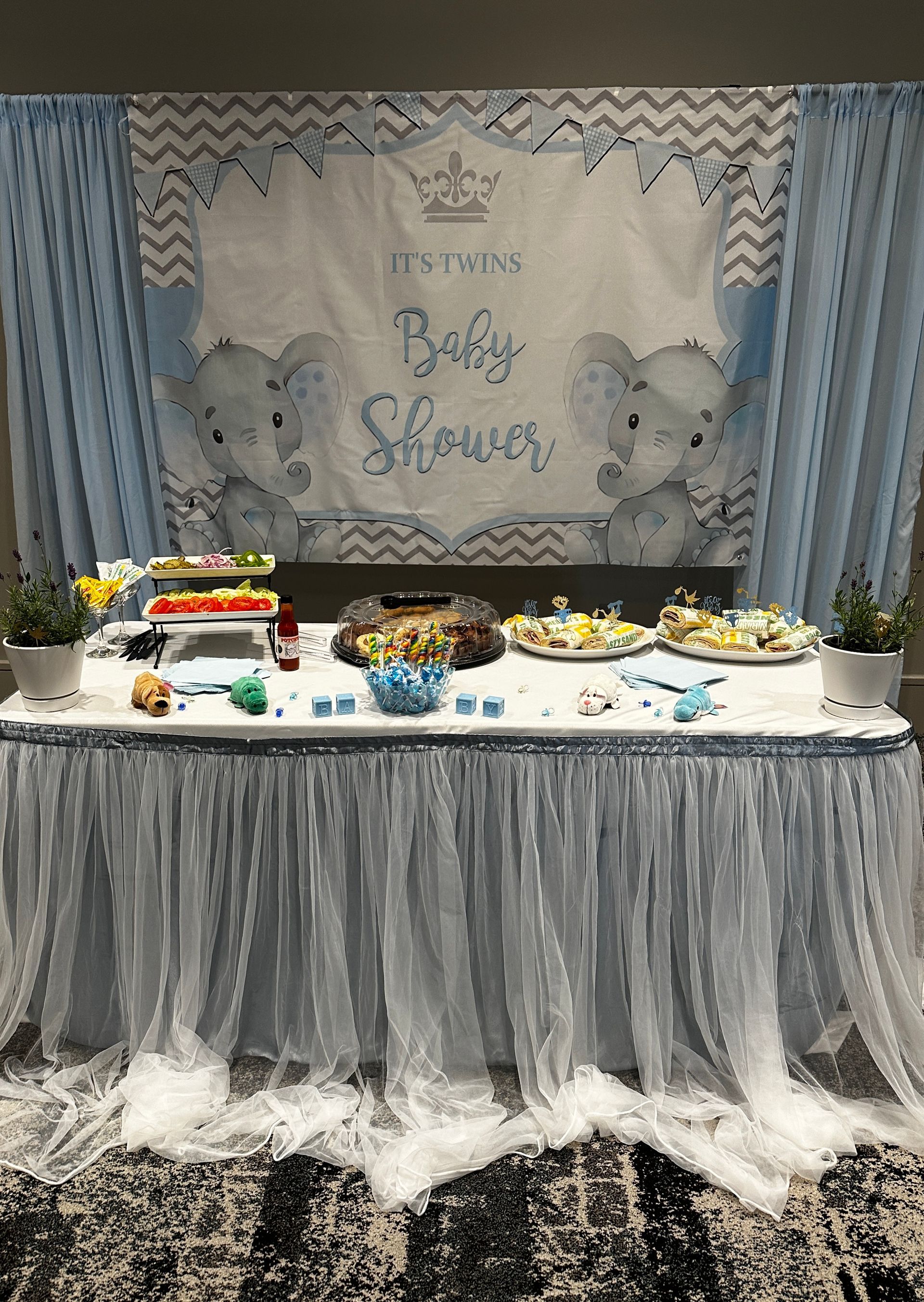 A table set up for a baby shower with an elephant backdrop.