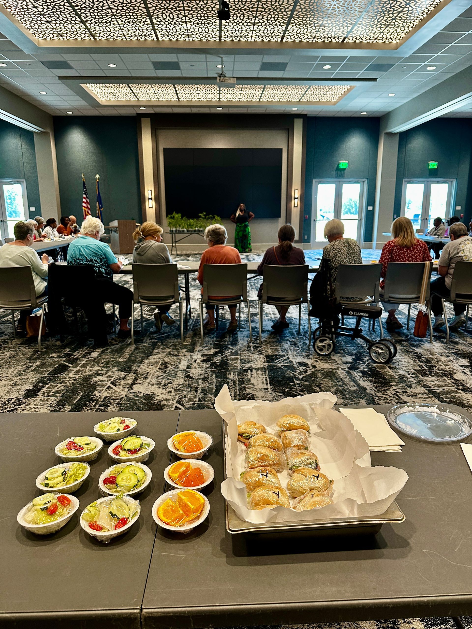 A group of people are sitting at tables in a large room.
