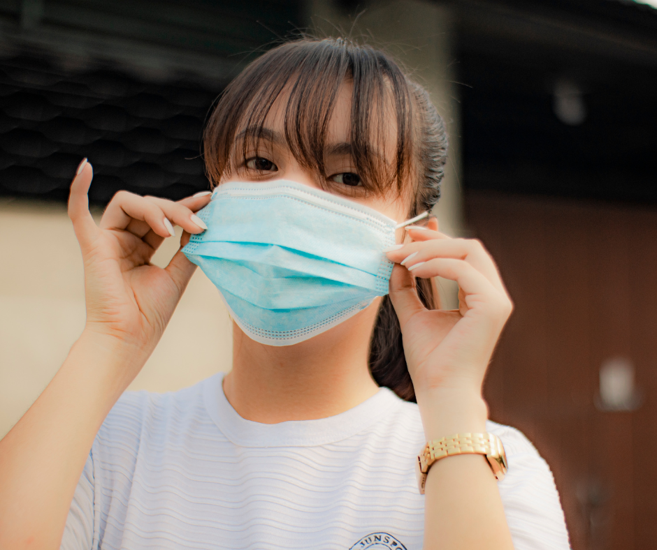 A woman is wearing a blue face mask on her face.