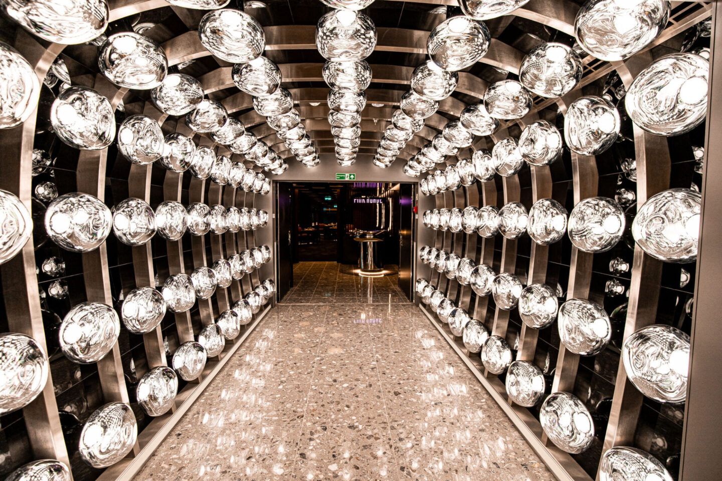 Mirror-lined hallway with rows of crystal-like lights and a glittering floor