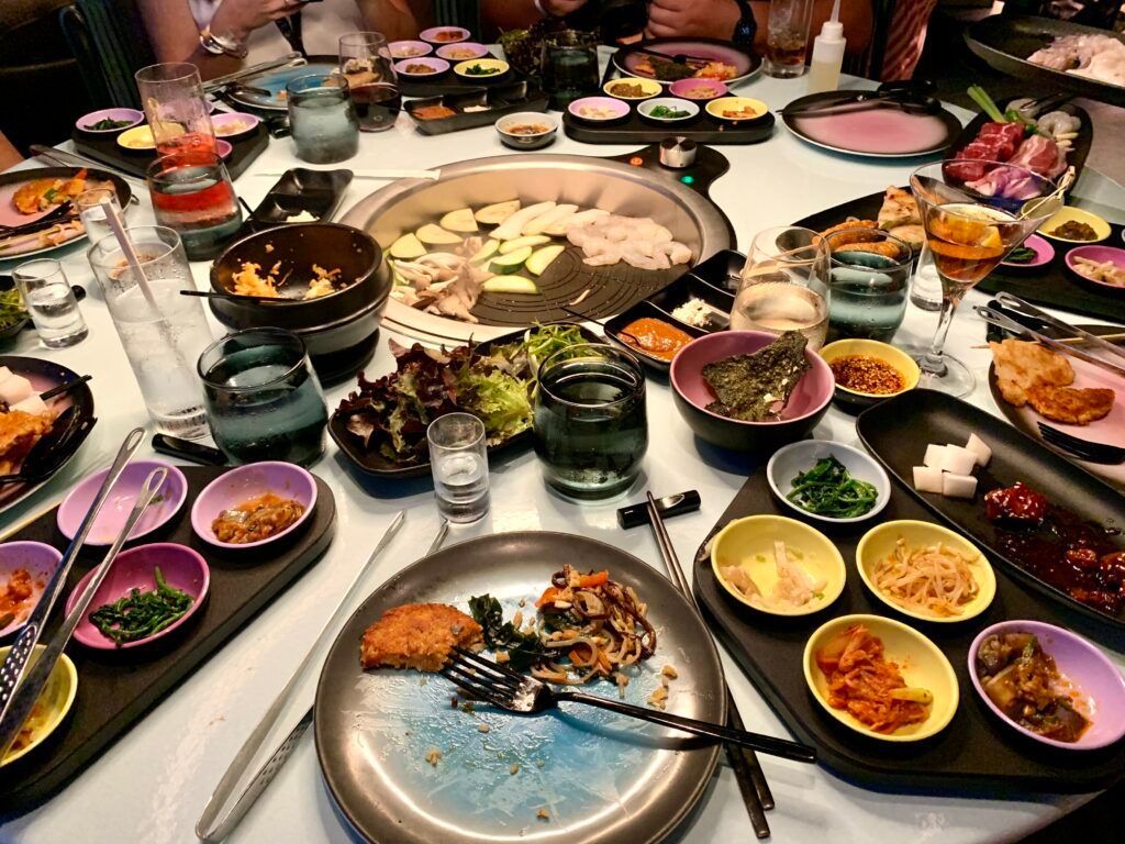 A table full of assorted dishes, bowls, and glasses arranged for a shared meal.