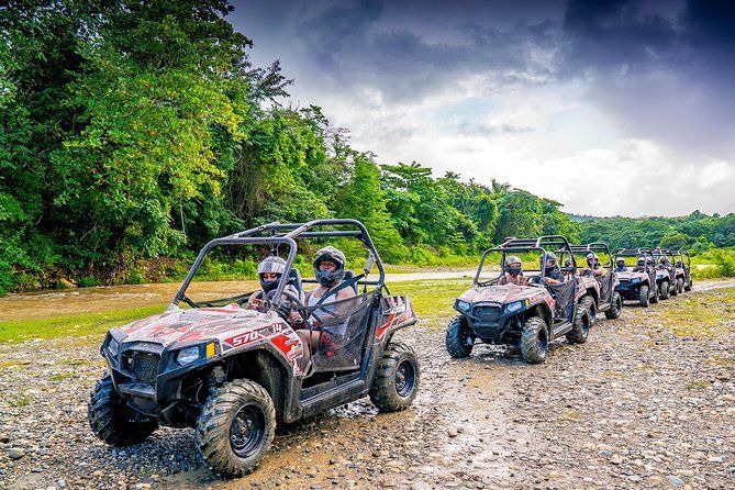 ATV convoy on a muddy forest trail under cloudy skies