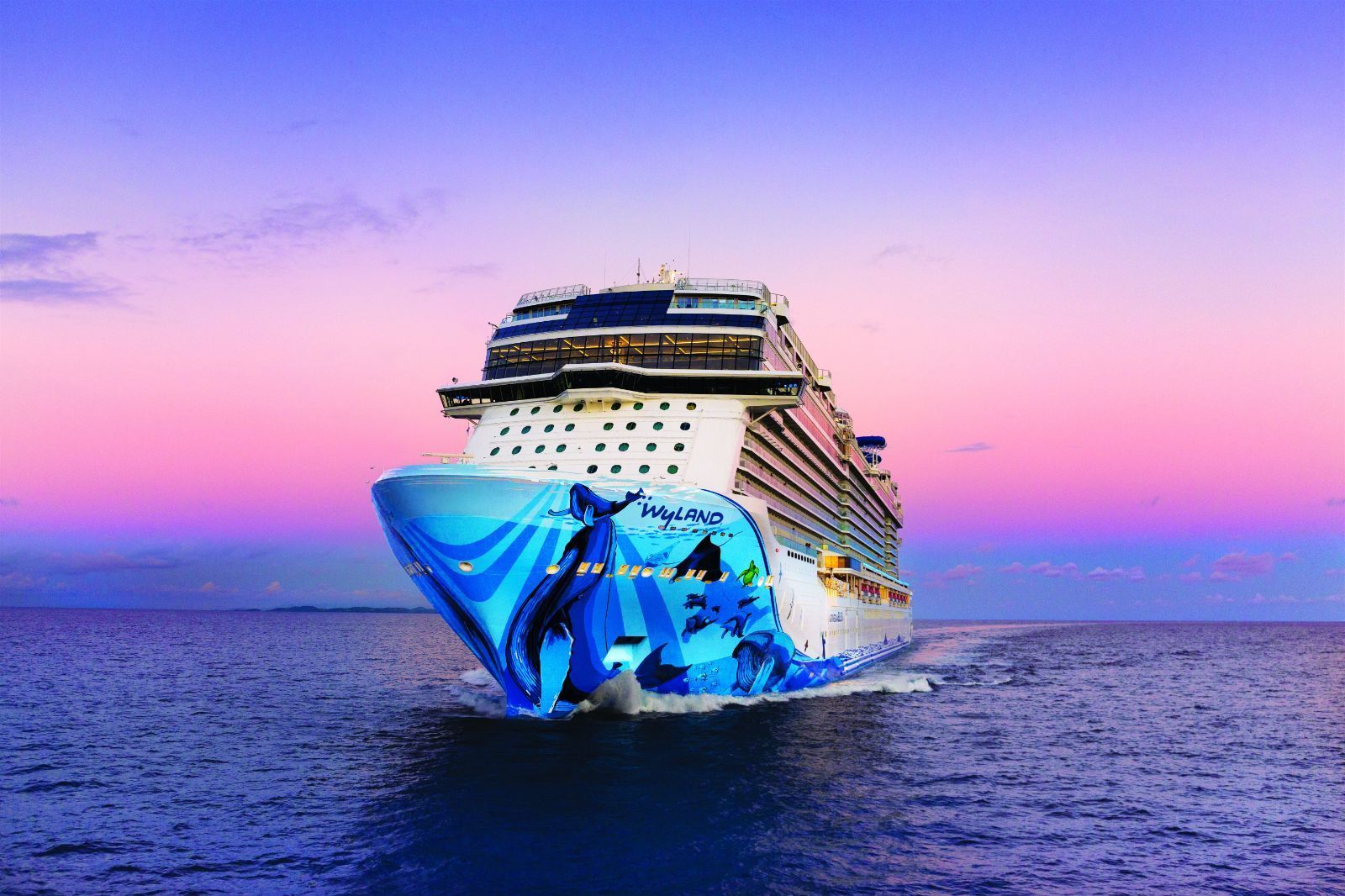 Large cruise ship with a colorful blue bow sailing on calm water at sunset