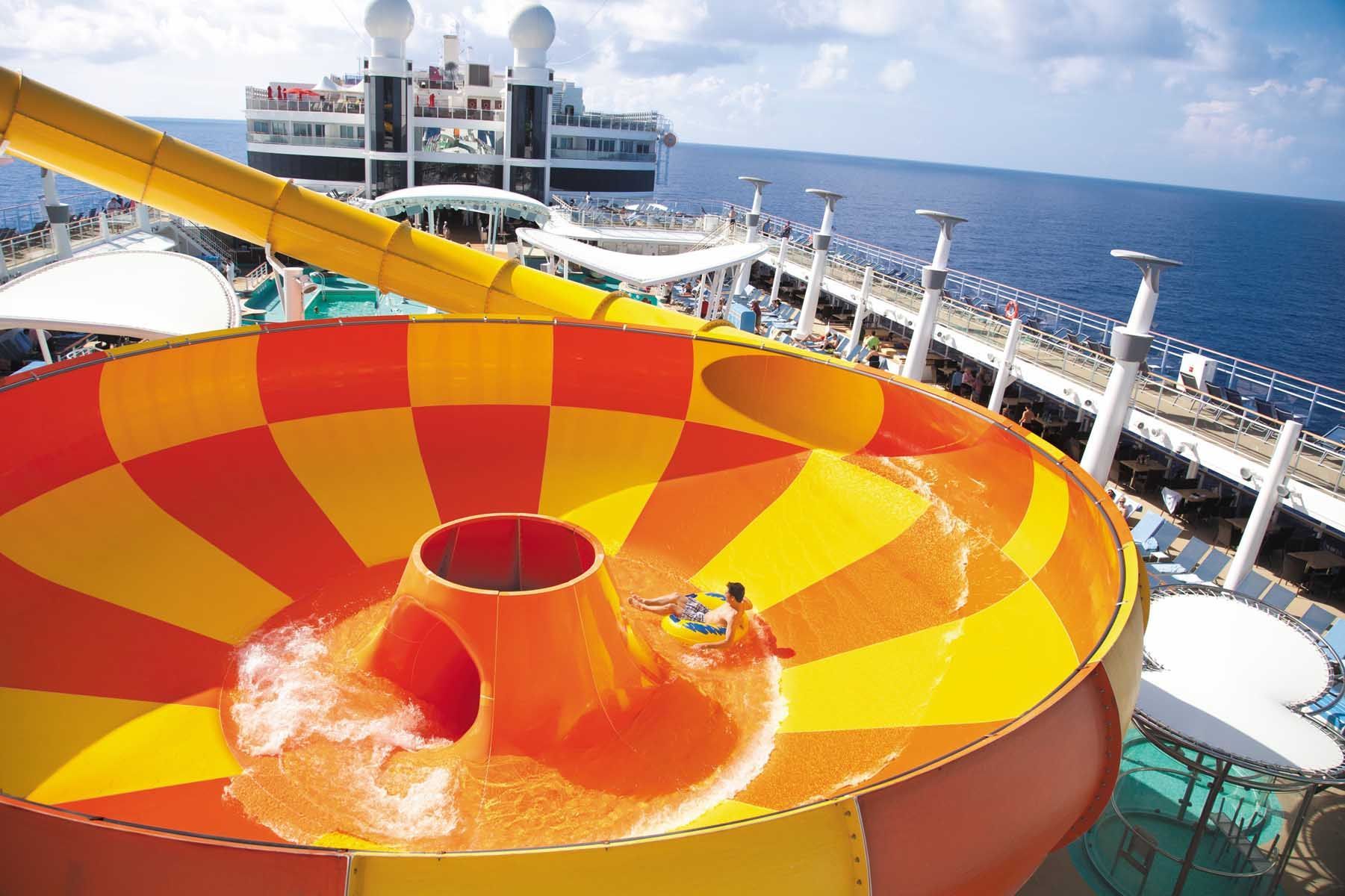 Cruise ship water slide with red and yellow spiral bowl, ocean and deck in background