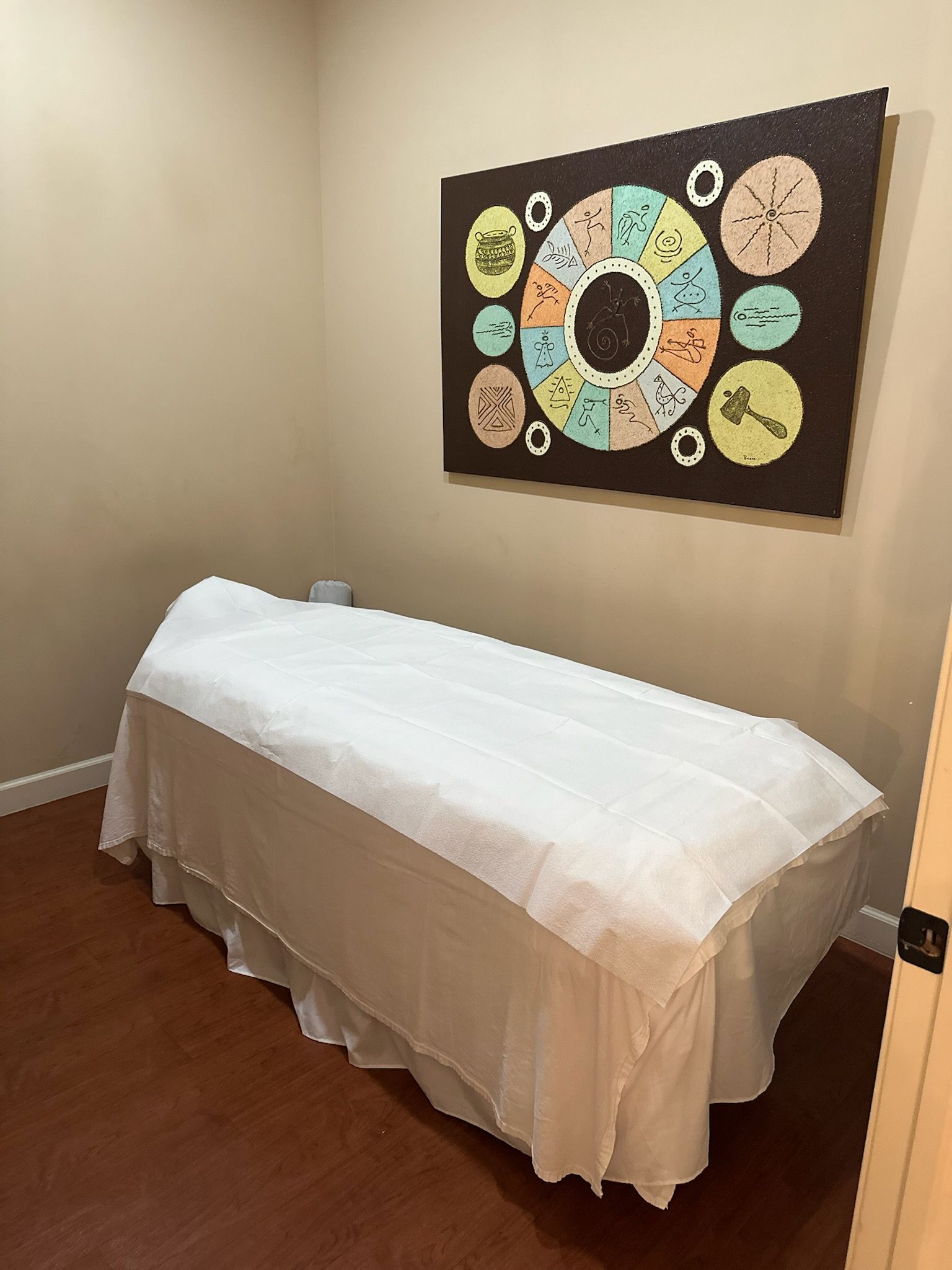 A smiling couple lying on massage tables while receiving shoulder and back massages in a spa.