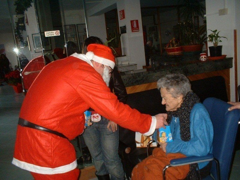Babbo Natale e regali ad anziana