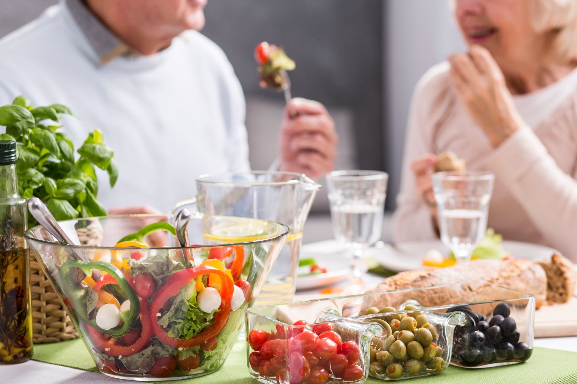Un uomo e una donna sono seduti a un tavolo e mangiano un'insalata.