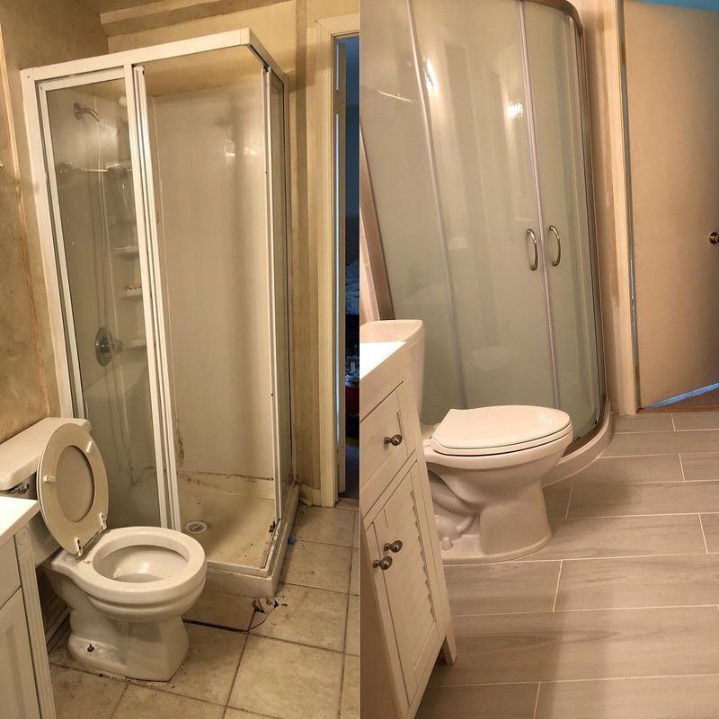 Bathroom with toilet, glass shower stall, and curved frosted glass cabinet beside a sink and tiled floor