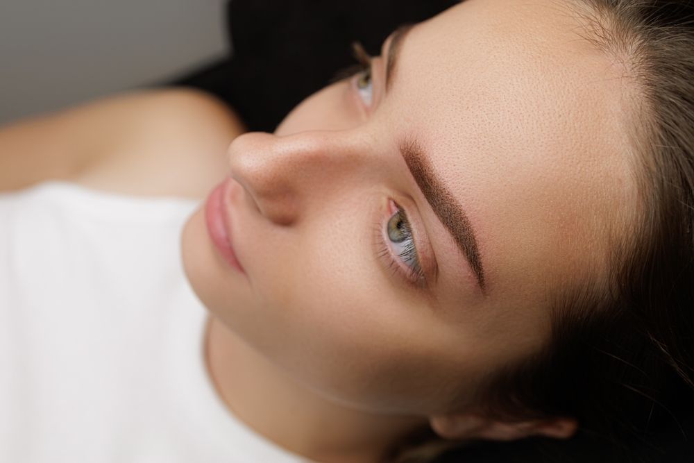 Close-up view of a person’s face showcasing professionally groomed, shaped eyebrows with defined, natural-looking strokes.