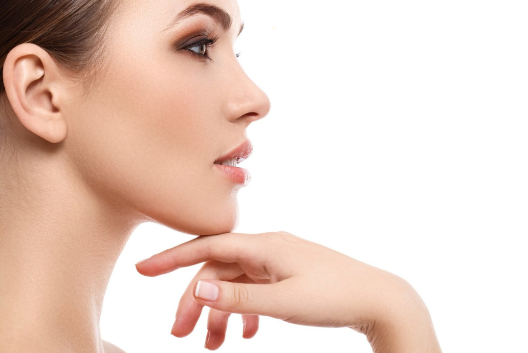 A close up of a woman 's face with her hand on her chin.