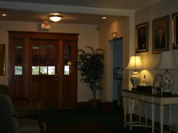 A hallway with a red exit sign above the door