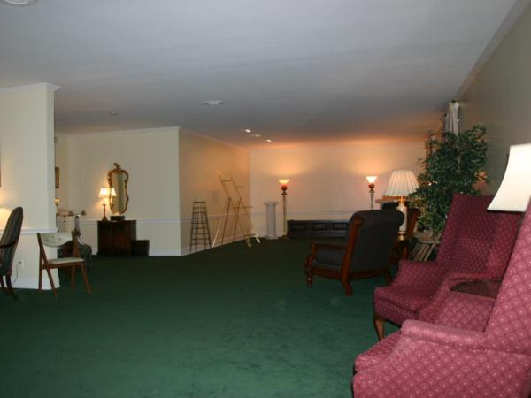 A living room with green carpet and red chairs