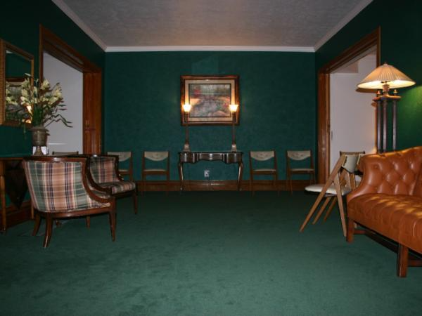 A living room with green walls and green carpet