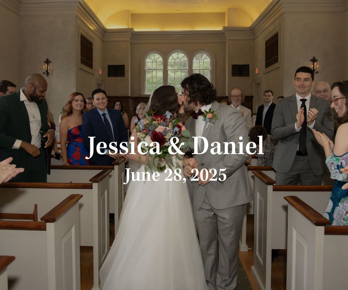 A bride and groom kiss while walking down the aisle of a chapel as wedding guests applaud. Text reads Jessica & Daniel.