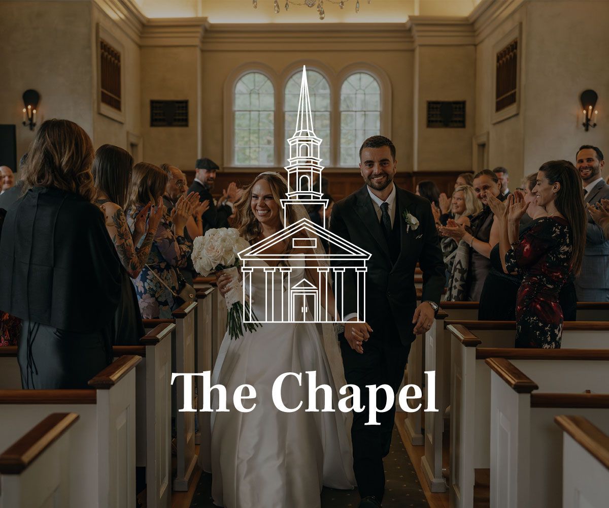A newlywed couple walks down the aisle of a chapel, smiling while wedding guests applaud. Overlay text reads, The Chapel.