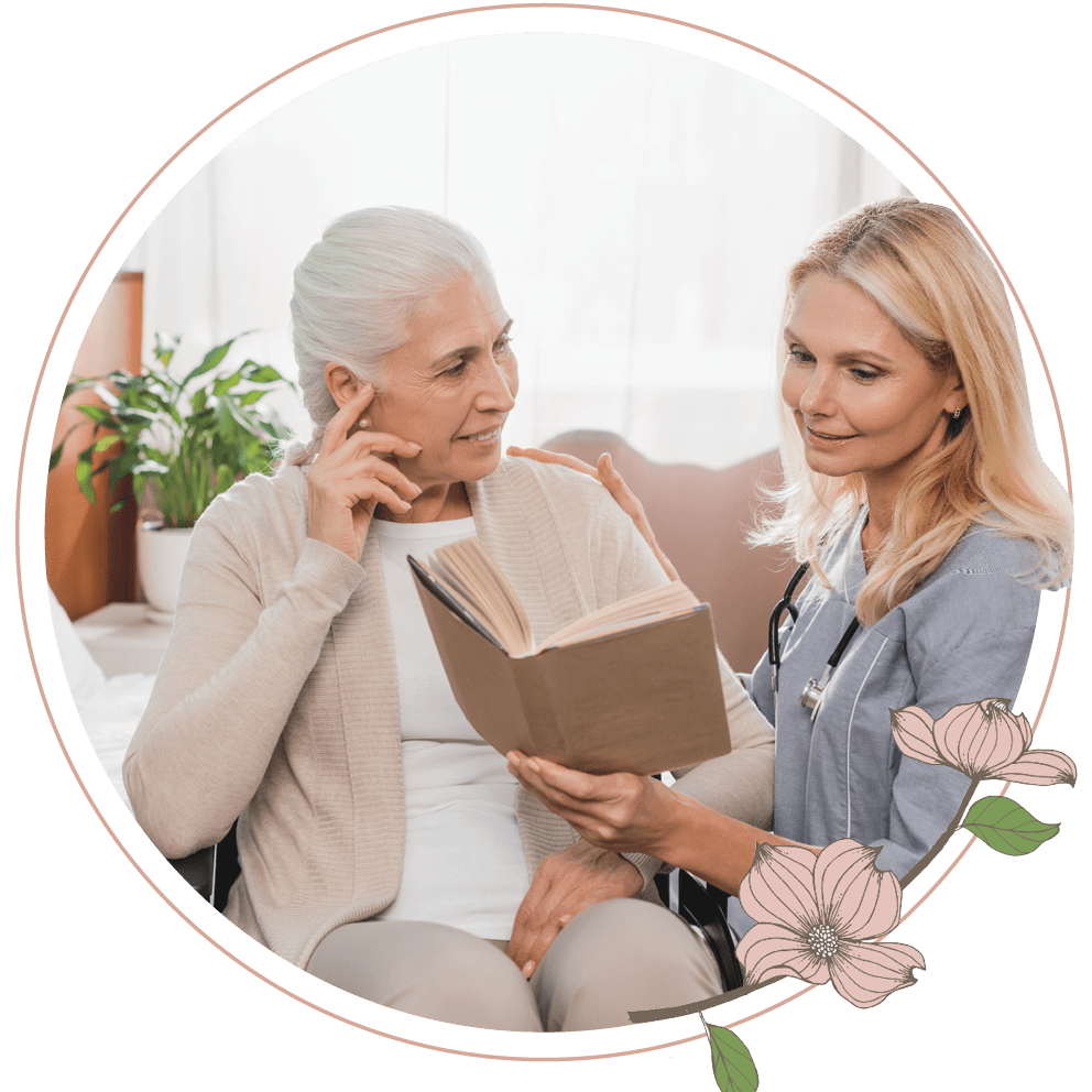 A nurse reading a book to an elderly woman