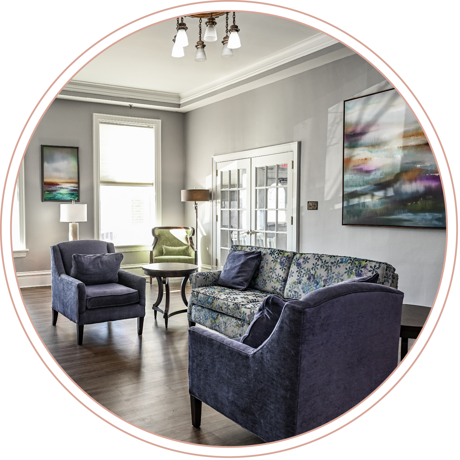 A living room with a couch and two chairs at a local assisted living facility