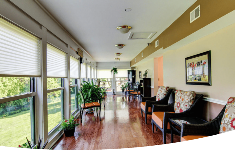 A long hallway with lots of windows and chairs