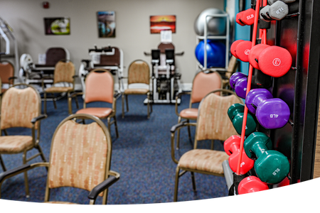 Short-Term Rehabilitation: Swift Recovery in Jefferson City: Short-Term Rehabilitation Services at Heisinger Bluffs Ensure Your Speedy Return to Wellness. A room with chairs and dumbbells