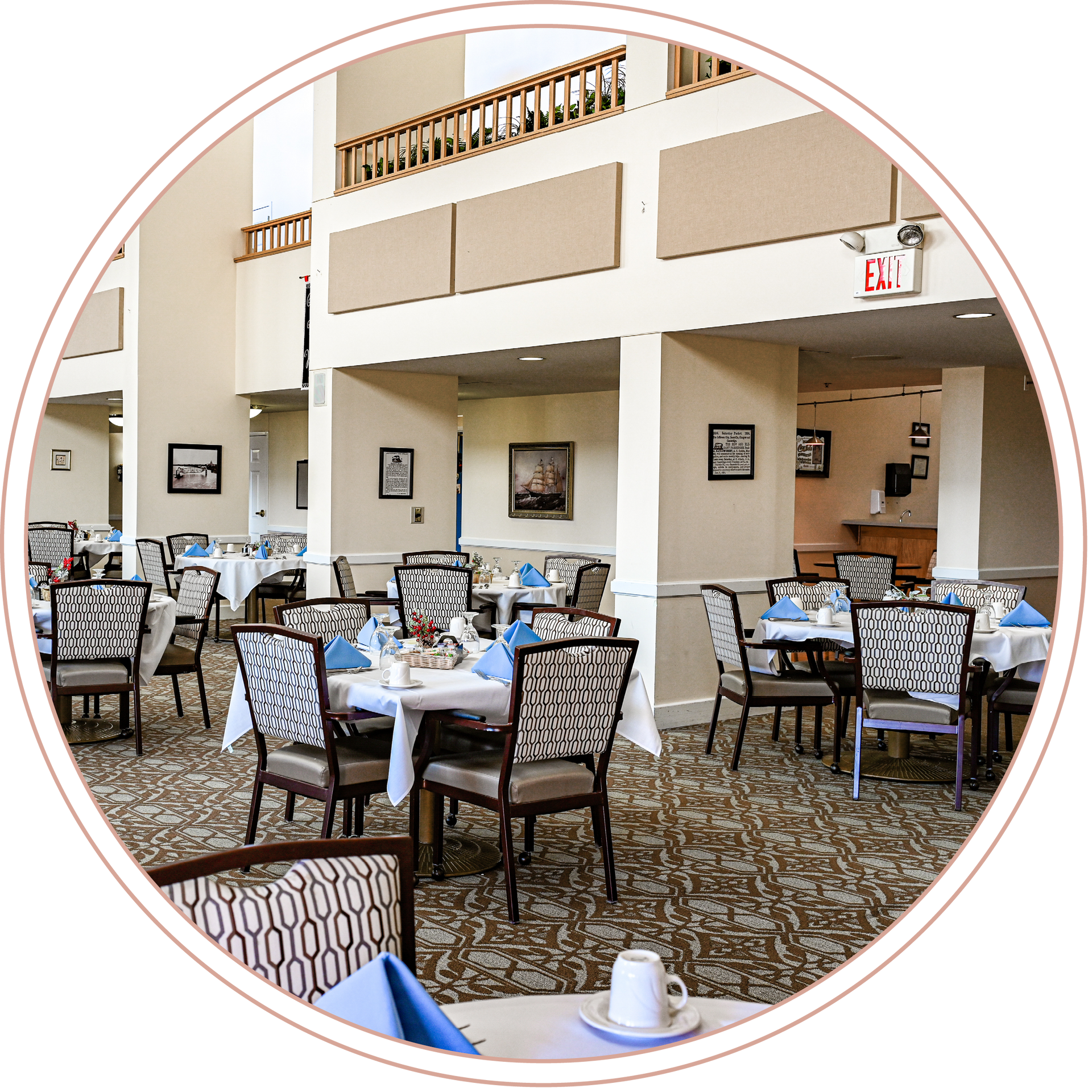A large dining room with tables and chairs and an exit sign at a local Independent living facility