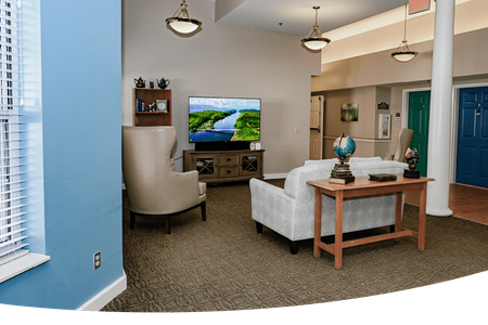 Memory Care: Compassionate Memory Care in Jefferson City, MO: Heisinger Bluffs' Dedicated Approach to Alzheimer's and Dementia Care. A living room with a couch, table, chairs. and a television set