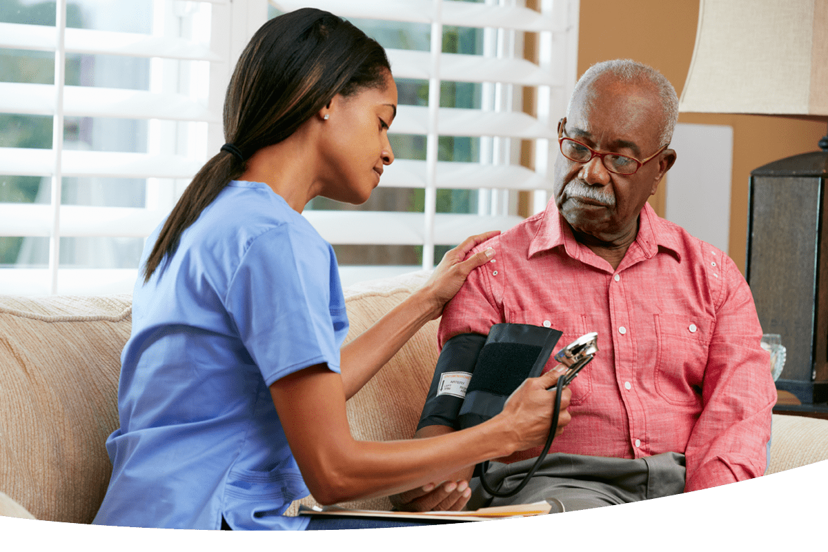 A nurse taking an elderly man's blood pressure