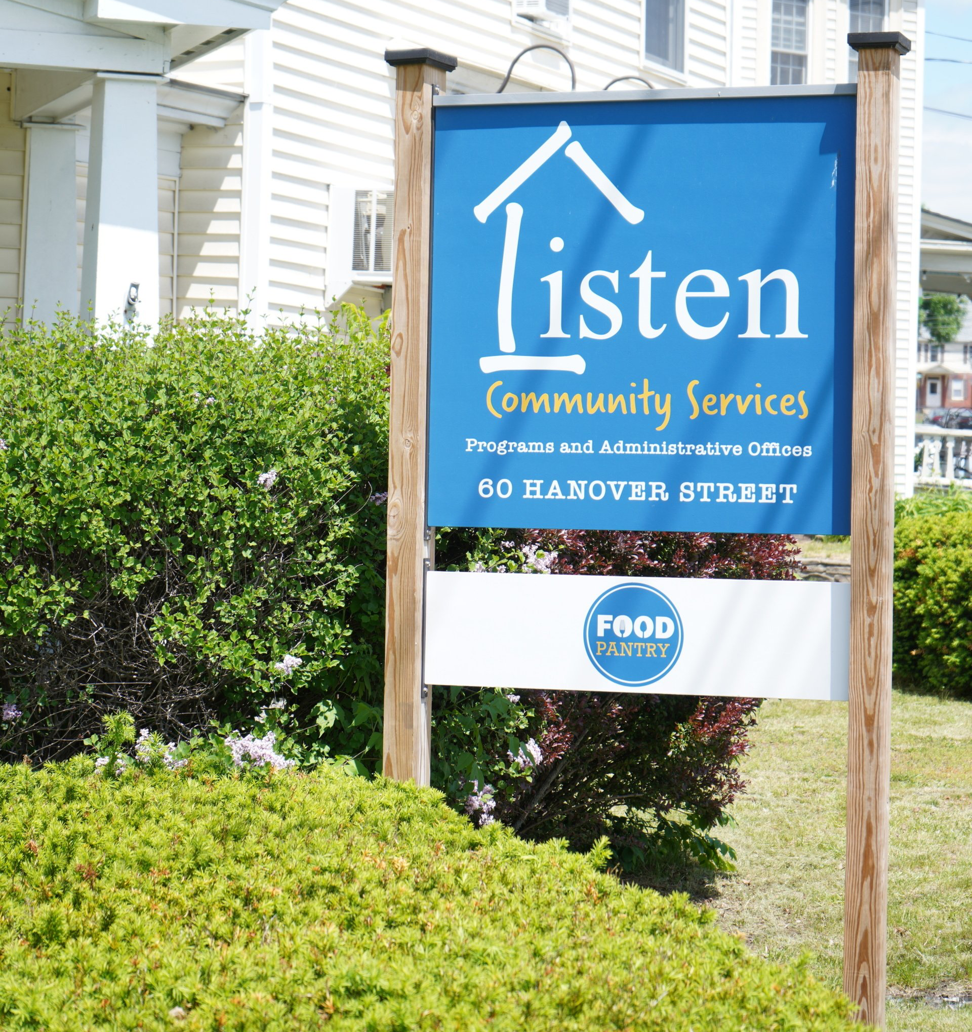 A blue sign that says listen community services on it