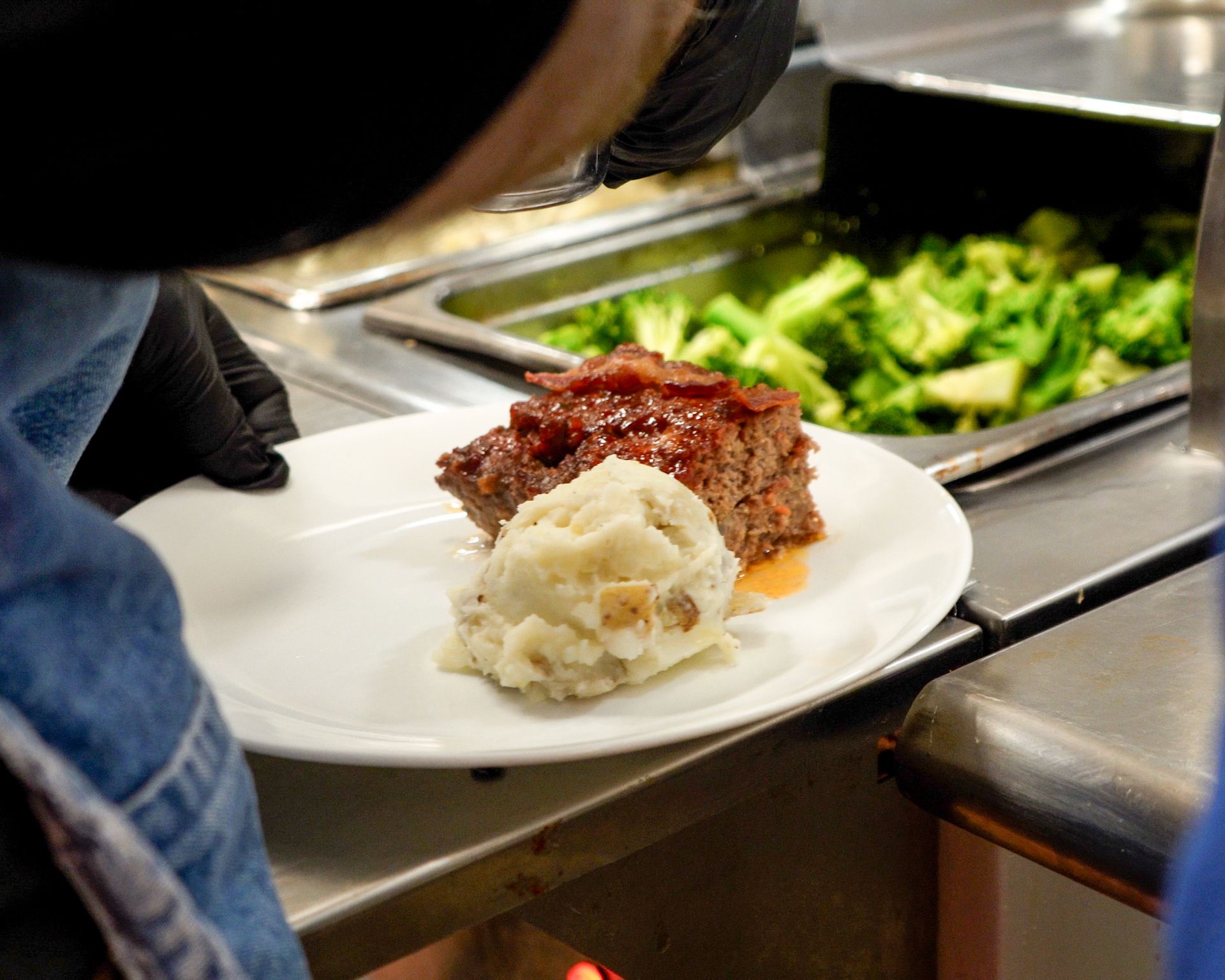 A person is putting a plate of food on a counter.