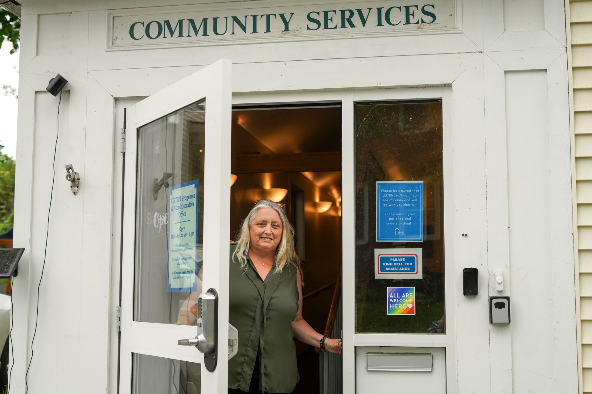 A woman is standing in the doorway of a community services building.