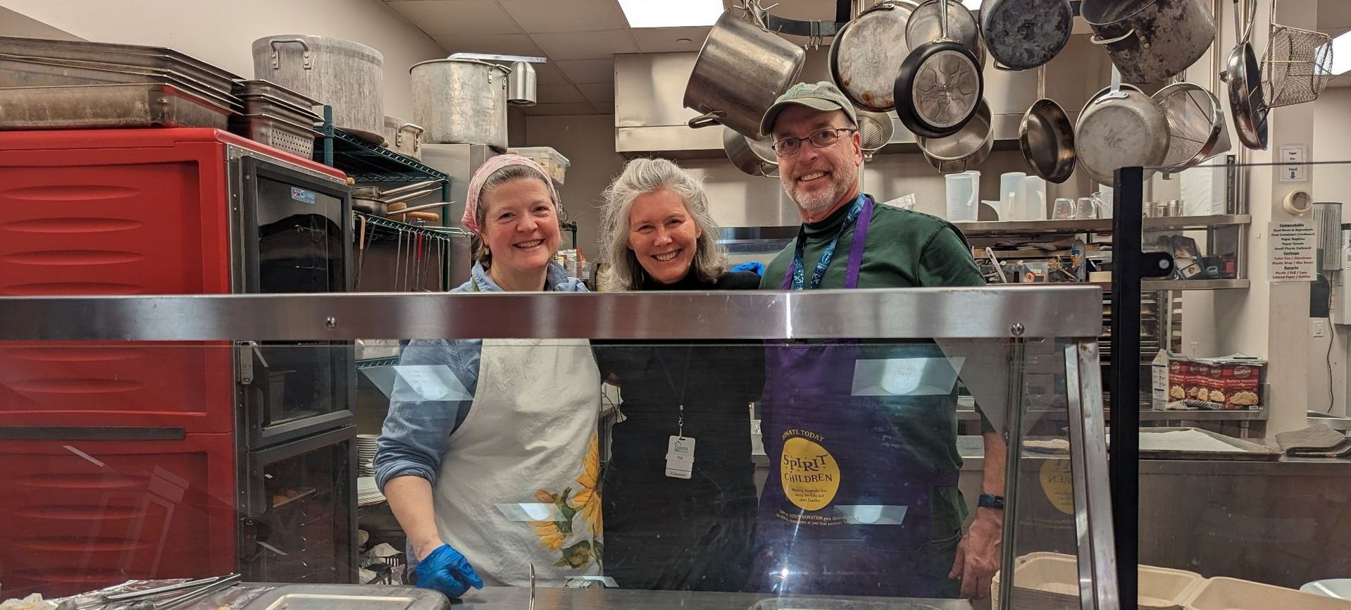 A group of people are posing for a picture in a kitchen.