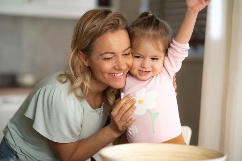 A woman and a little girl are sitting at a table.