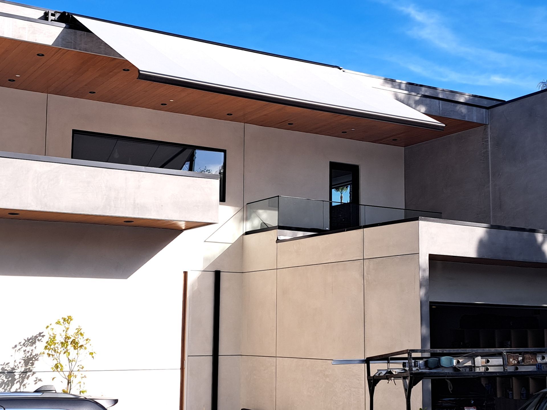 Modern building exterior with balconies, beige walls, and a blue sky above