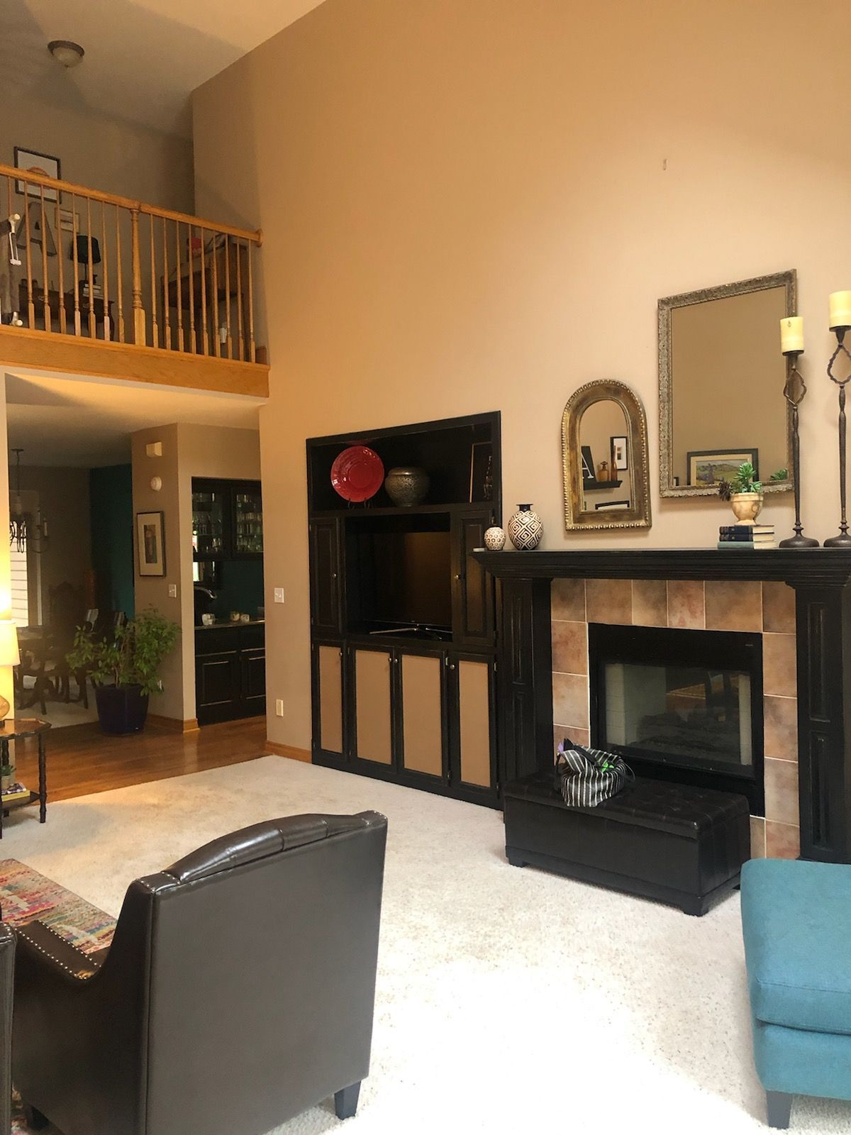 Living room with fireplace, built-in entertainment center, and loft overlooking the space.