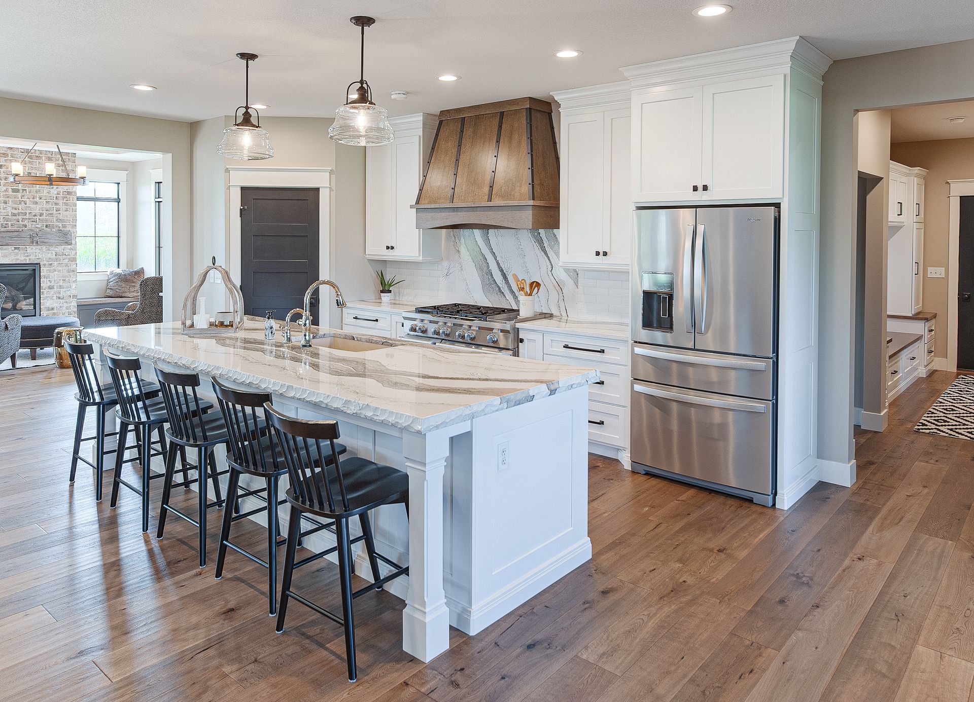Marble island table with white cabinets, modern fridge and stove.